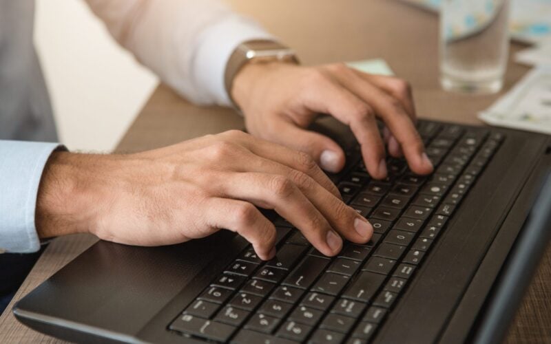 Young male business traveler hotel accomodation working